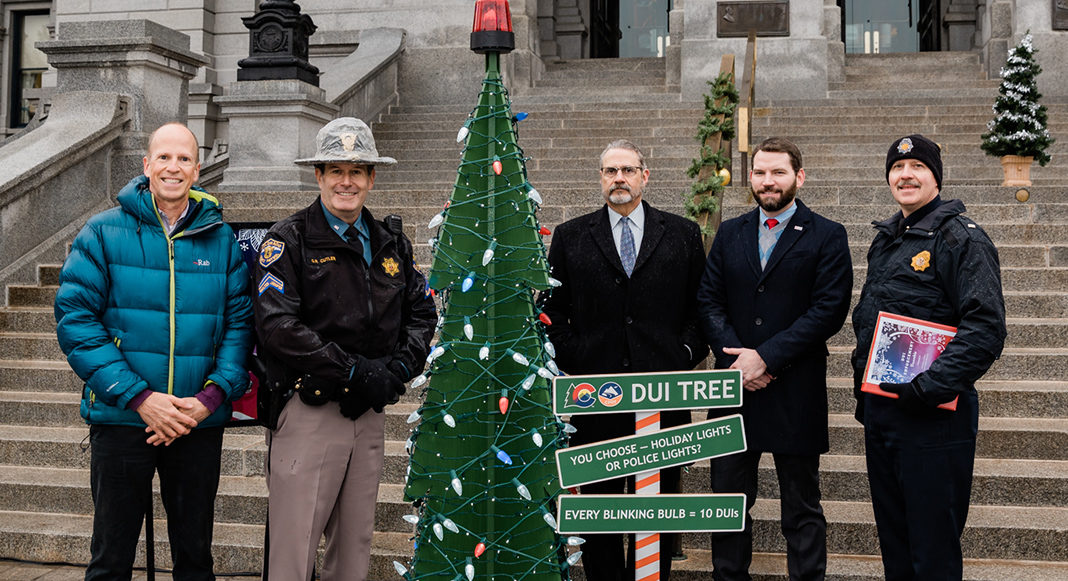The 3D “DUI Tree” is decorated with 100 large white holiday lights. For every 10 DUIs reported during the enforcement period, a white bulb will be replaced on the tree with a red or blue bulb to represent police lights. Signs accompany the tree with the message, “You Choose — Holiday Lights or Police Lights.”